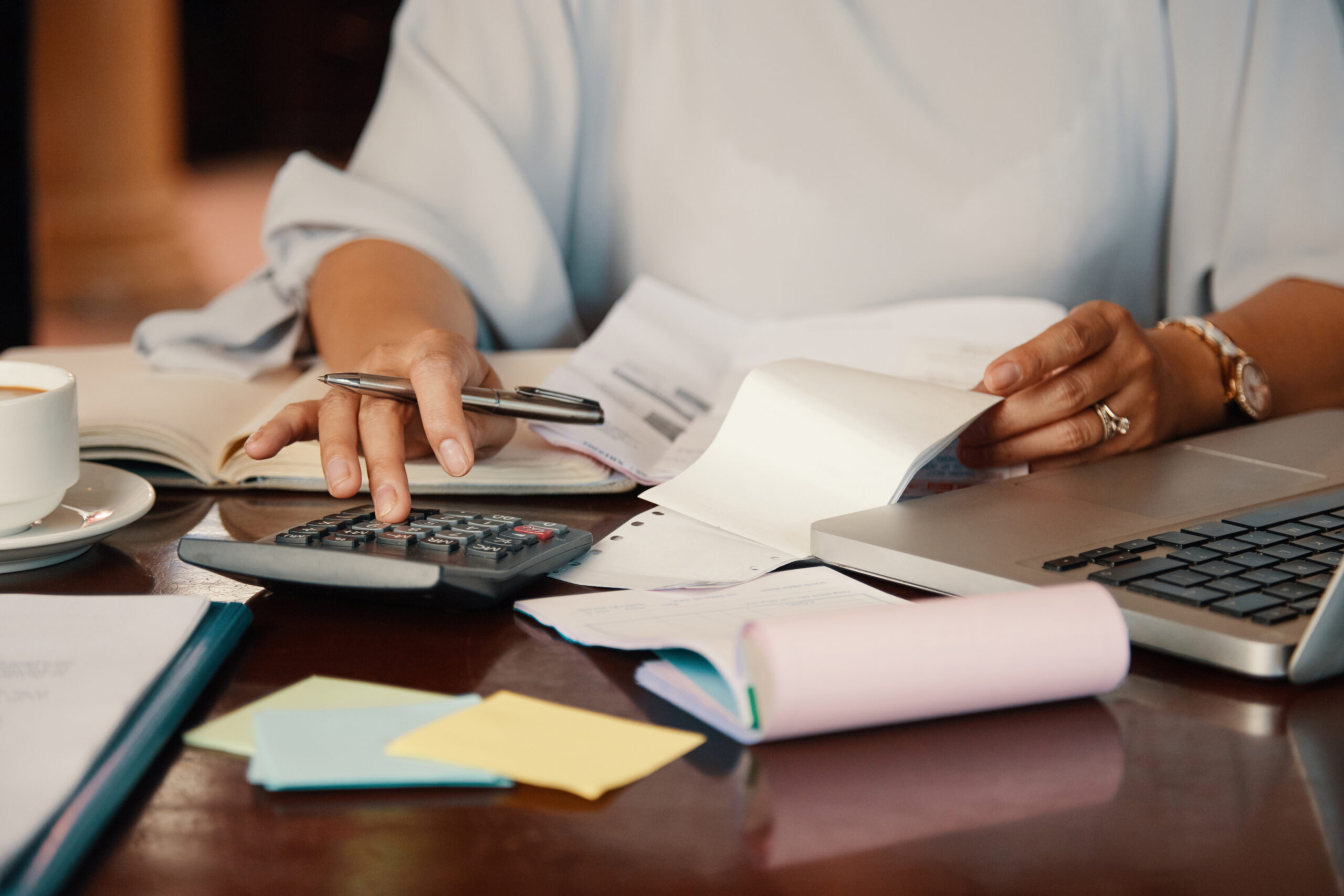 Hands of female entrepreneur working with bills and documents