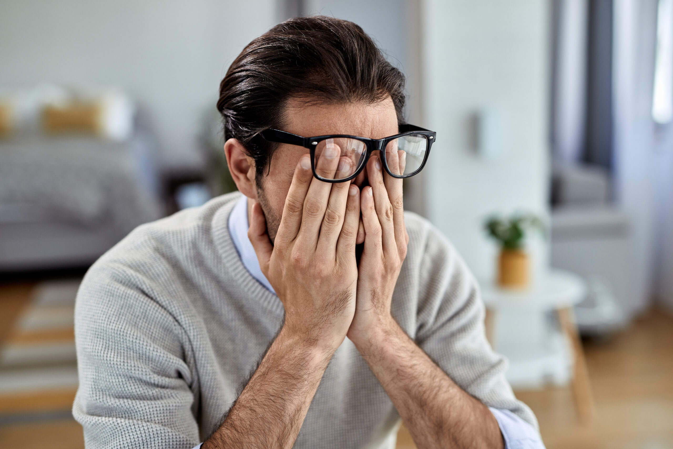 Young businessman feeling exhausted while working at home.